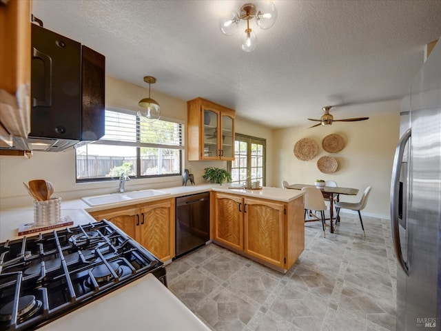 kitchen with glass insert cabinets, a sink, light countertops, a ceiling fan, and black appliances