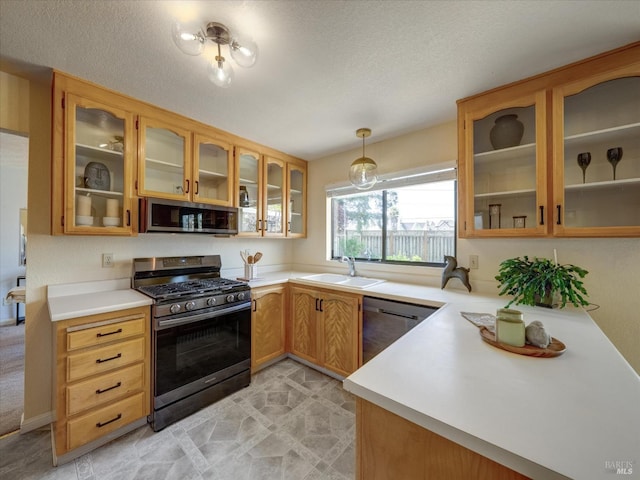 kitchen featuring light countertops, a sink, glass insert cabinets, and stainless steel appliances