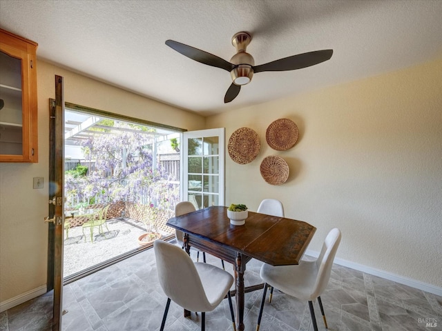 dining area with ceiling fan and baseboards