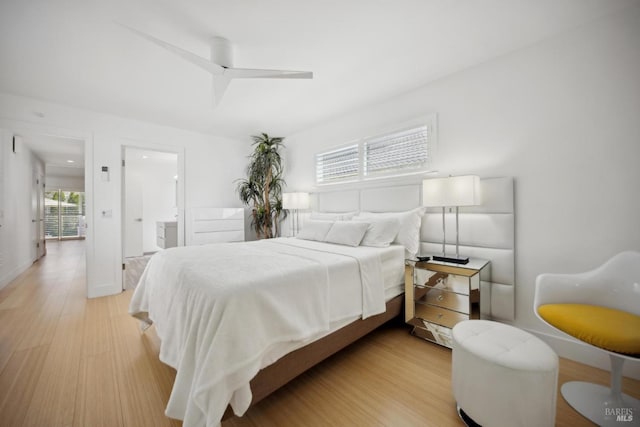 bedroom with light wood-style floors, ensuite bathroom, and ceiling fan