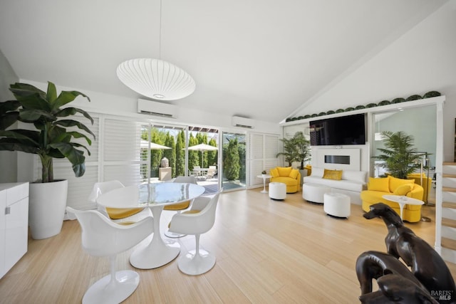interior space with wood finished floors, vaulted ceiling, and a wall unit AC