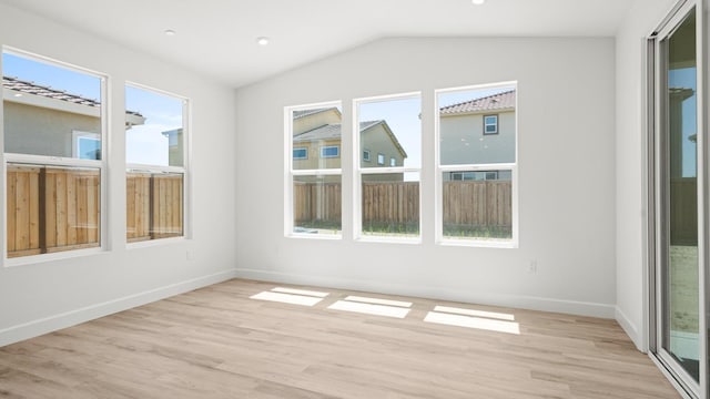 empty room with light wood-style floors, recessed lighting, baseboards, and lofted ceiling