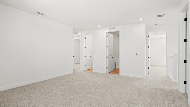 unfurnished bedroom featuring recessed lighting, baseboards, visible vents, and light carpet