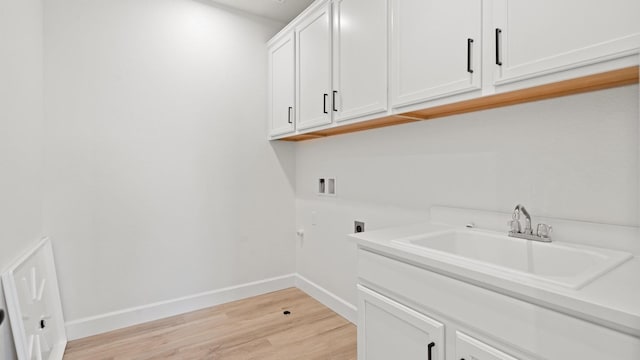 laundry room featuring cabinet space, washer hookup, light wood-style floors, baseboards, and hookup for an electric dryer