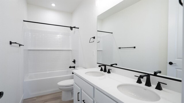full bathroom featuring double vanity, a sink, wood finished floors, and toilet