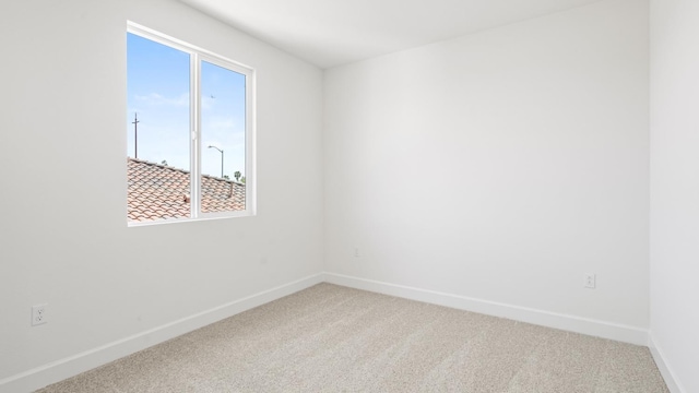 unfurnished room with baseboards and carpet flooring