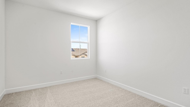 empty room with baseboards and light colored carpet