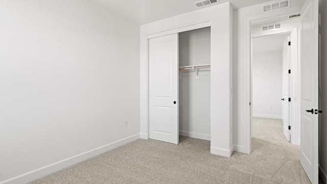 unfurnished bedroom with visible vents, carpet, baseboards, and a closet