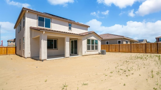 back of property featuring cooling unit, a fenced backyard, stucco siding, a patio area, and a tile roof