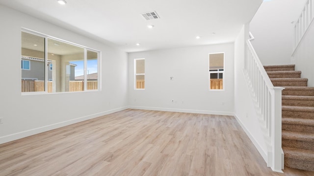 unfurnished living room featuring recessed lighting, visible vents, stairway, and light wood-type flooring