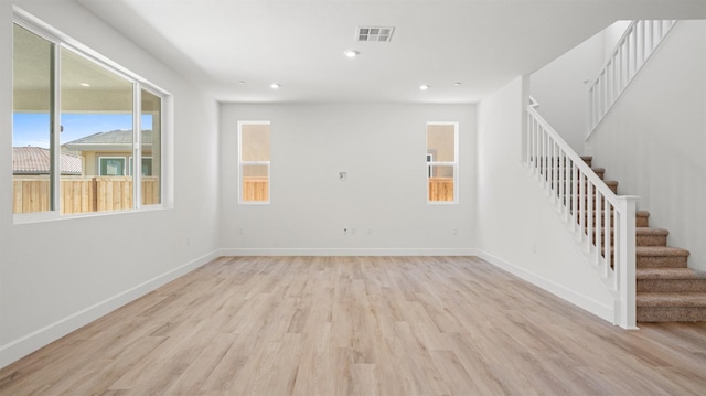 unfurnished living room featuring stairs, recessed lighting, baseboards, wood finished floors, and visible vents