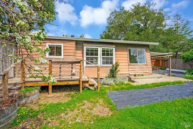 rear view of house with fence and a wooden deck