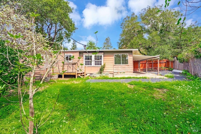 back of property with fence and a yard
