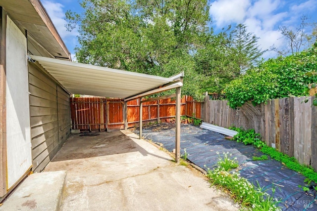 view of patio / terrace featuring a carport, a fenced backyard, and driveway