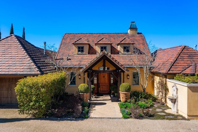 view of front of house featuring a chimney and stucco siding
