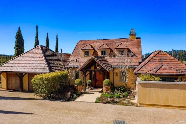 view of front of house featuring stucco siding and a chimney