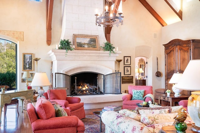 living room featuring an inviting chandelier, a fireplace, beamed ceiling, wood finished floors, and high vaulted ceiling