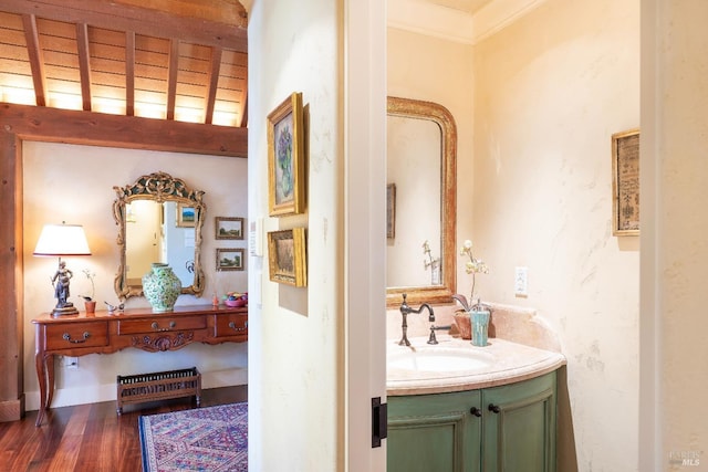 bathroom with vanity, ornamental molding, and wood finished floors