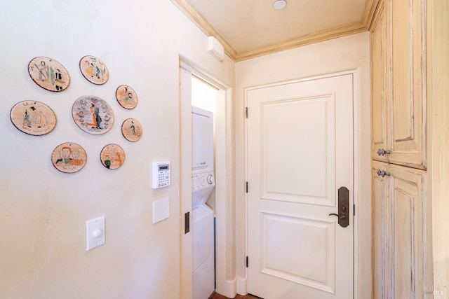 hallway featuring ornamental molding and stacked washer and clothes dryer