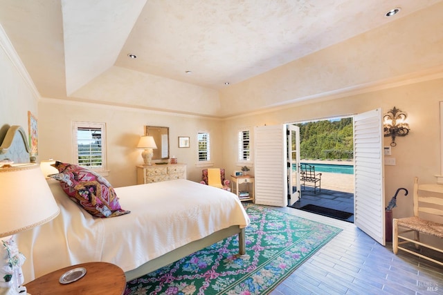 bedroom featuring wood finished floors, access to outside, ornamental molding, and a raised ceiling