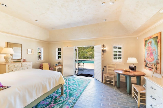 bedroom featuring lofted ceiling, access to outside, ornamental molding, and a raised ceiling
