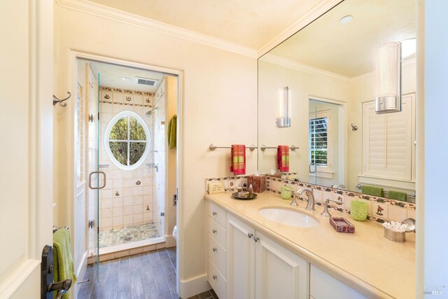full bath with visible vents, toilet, crown molding, a shower stall, and wood finished floors