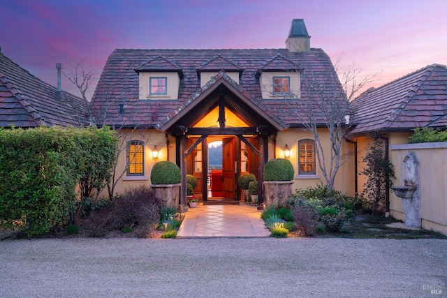 view of front of property featuring a chimney and stucco siding