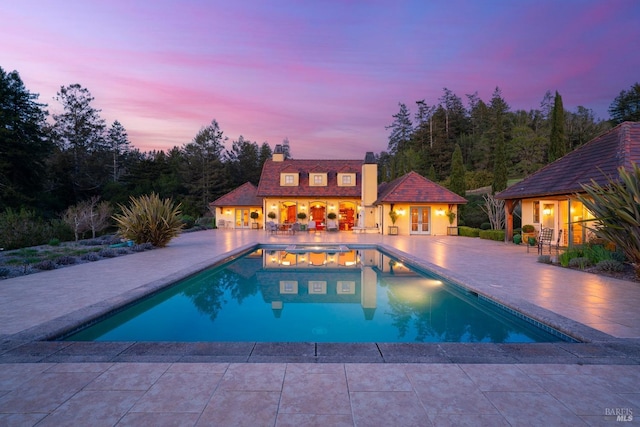 outdoor pool with a patio area, a storage structure, and an outdoor structure