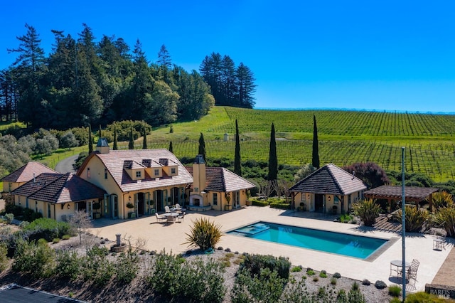 outdoor pool with a patio area, a gazebo, fence, and a rural view