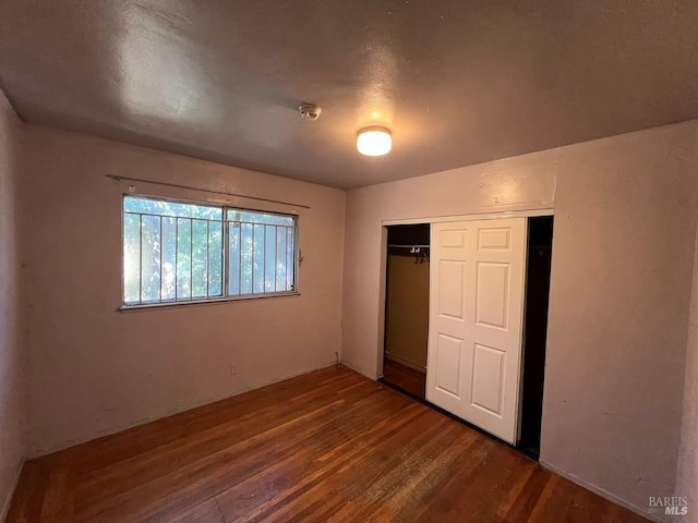 unfurnished bedroom featuring a closet and wood finished floors