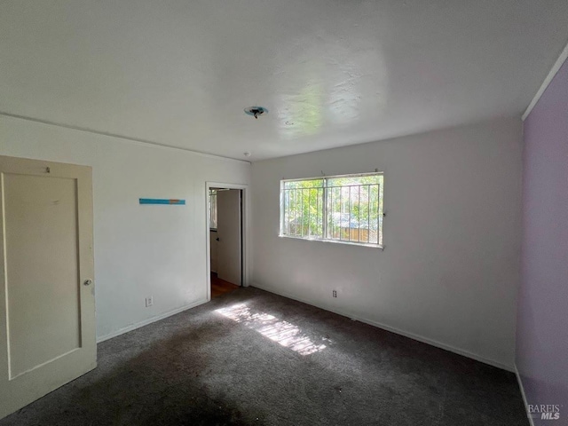 empty room featuring carpet floors and baseboards