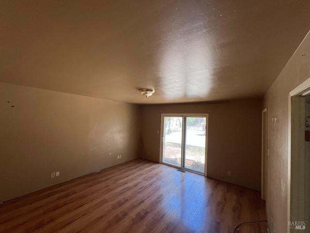 spare room featuring wood finished floors