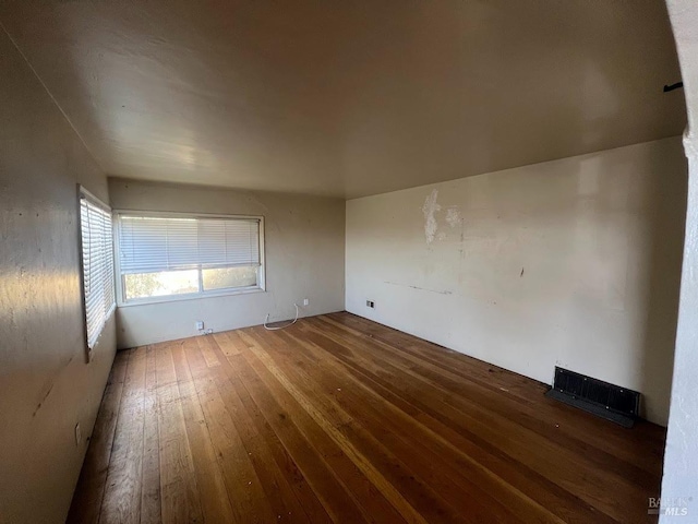 empty room featuring wood-type flooring and visible vents