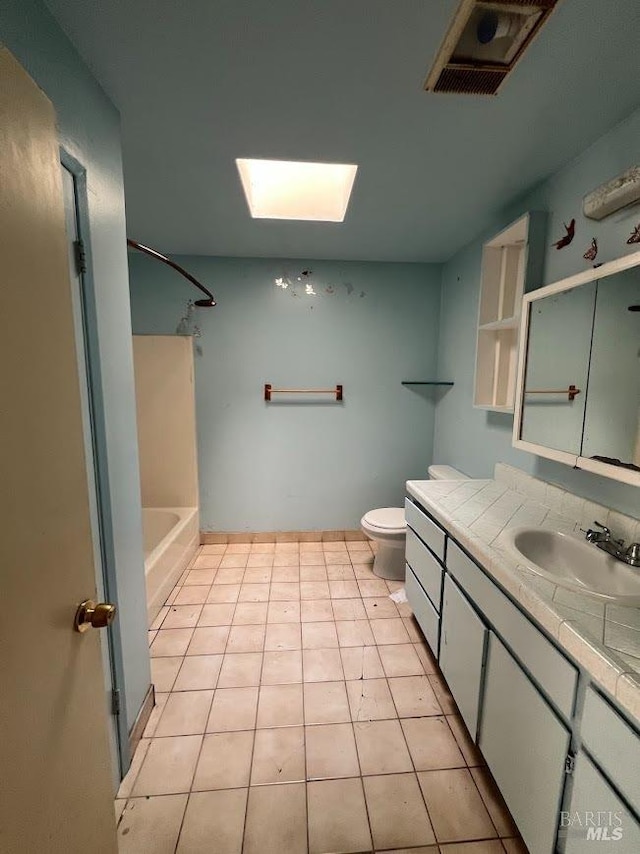 bathroom with visible vents, a skylight, tile patterned flooring, vanity, and toilet