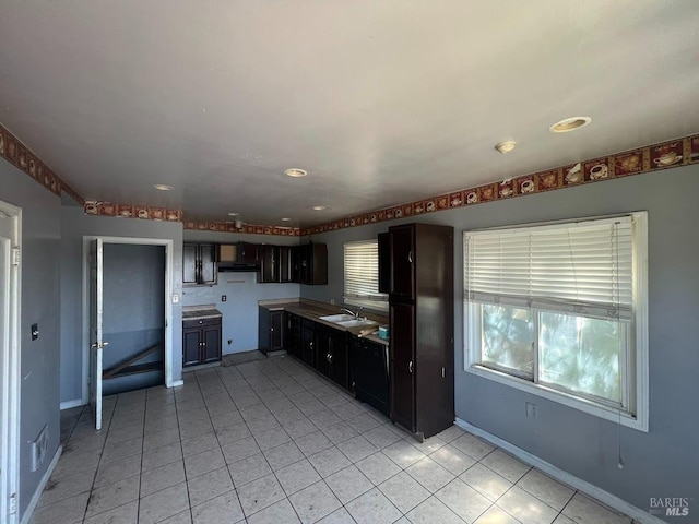 kitchen featuring recessed lighting, baseboards, a sink, and light tile patterned floors