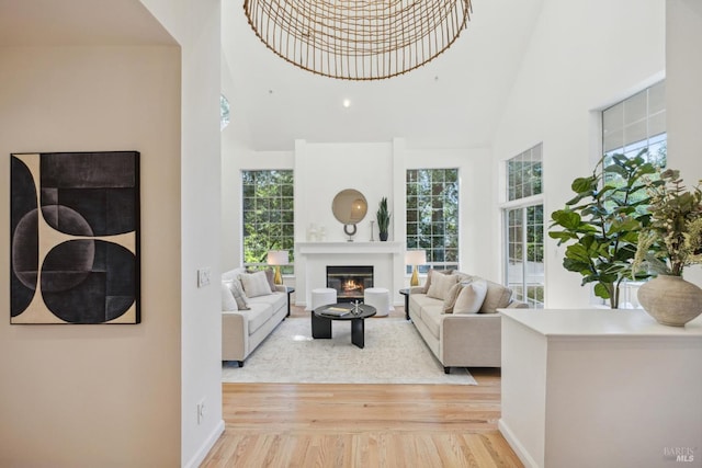 240 Del Casa Dr, Mill Valley, CA 94941 - living room featuring a glass covered fireplace, light wood finished floors, a high ceiling, and baseboards