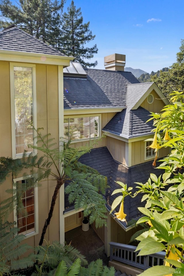 240 Del Casa Dr, Mill Valley, CA 94941 - view of home's exterior with board and batten siding, a chimney, a shingled roof, and a mountain view