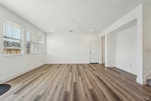 unfurnished room with wood finished floors, baseboards, visible vents, and recessed lighting