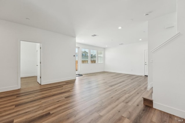 unfurnished living room featuring light wood-style flooring, baseboards, visible vents, and recessed lighting