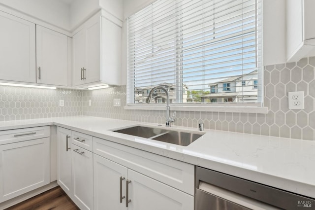 kitchen with decorative backsplash, dishwasher, a sink, and white cabinets