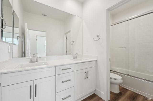 bathroom with a sink, visible vents, toilet, and wood finished floors