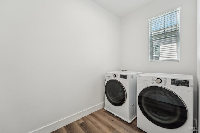 laundry room with washer and dryer, laundry area, baseboards, and wood finished floors