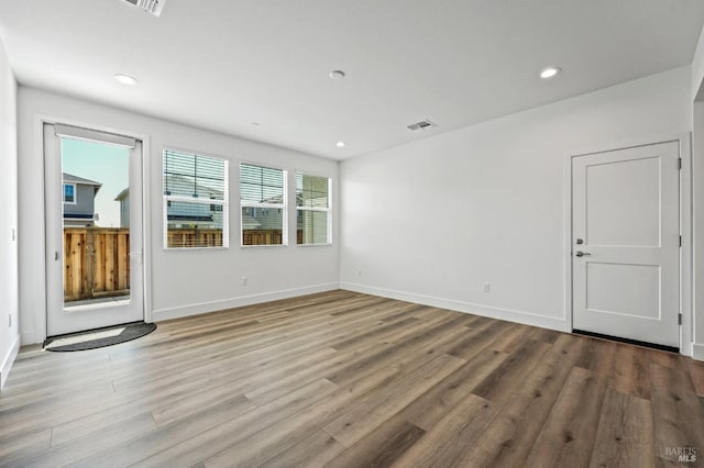 empty room featuring recessed lighting, visible vents, baseboards, and wood finished floors