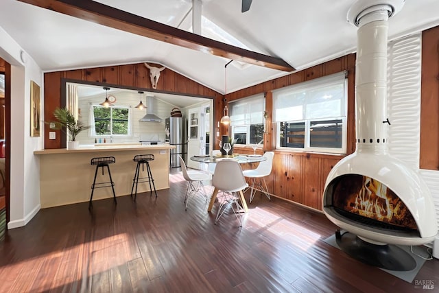 dining area featuring wooden walls, dark wood-type flooring, and lofted ceiling