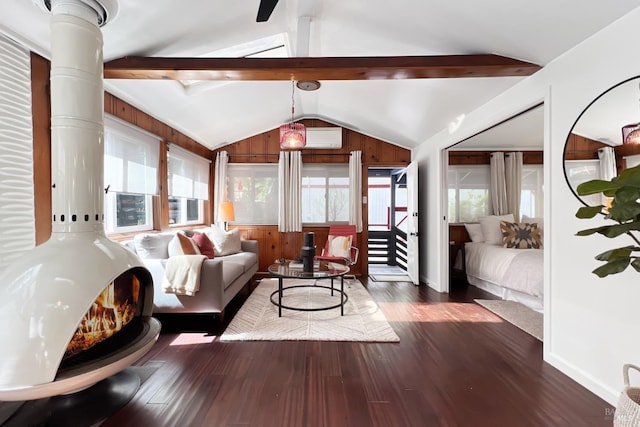 living room featuring wood walls, wood finished floors, lofted ceiling with beams, and a wall unit AC