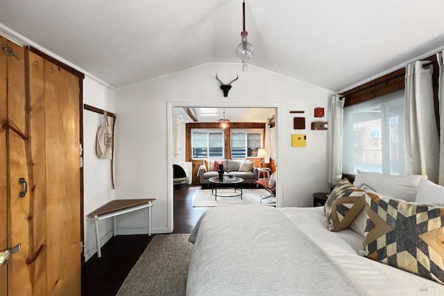 bedroom with dark wood finished floors and lofted ceiling