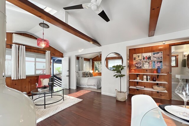 living area featuring a ceiling fan, wood finished floors, vaulted ceiling with beams, and an AC wall unit