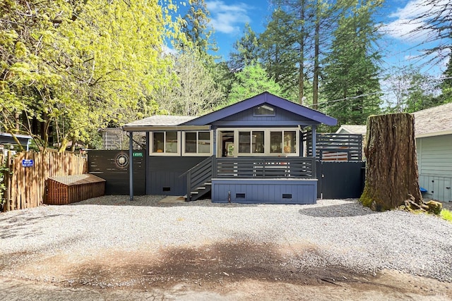 view of front of home featuring fence, a sunroom, and crawl space