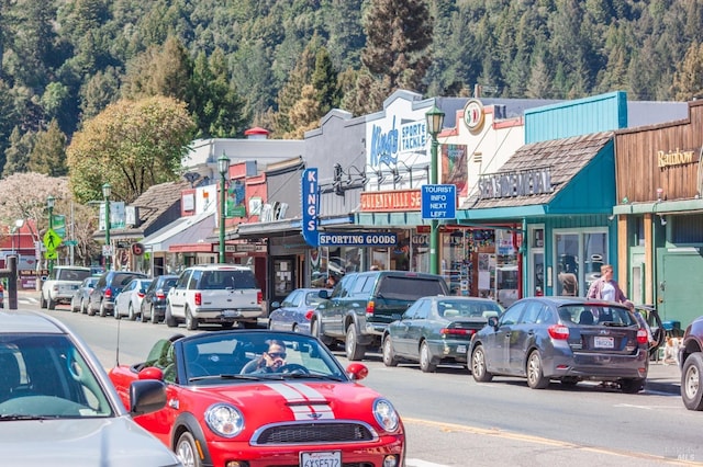 view of vehicle parking featuring a view of trees