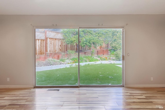 entryway featuring visible vents, baseboards, and wood finished floors